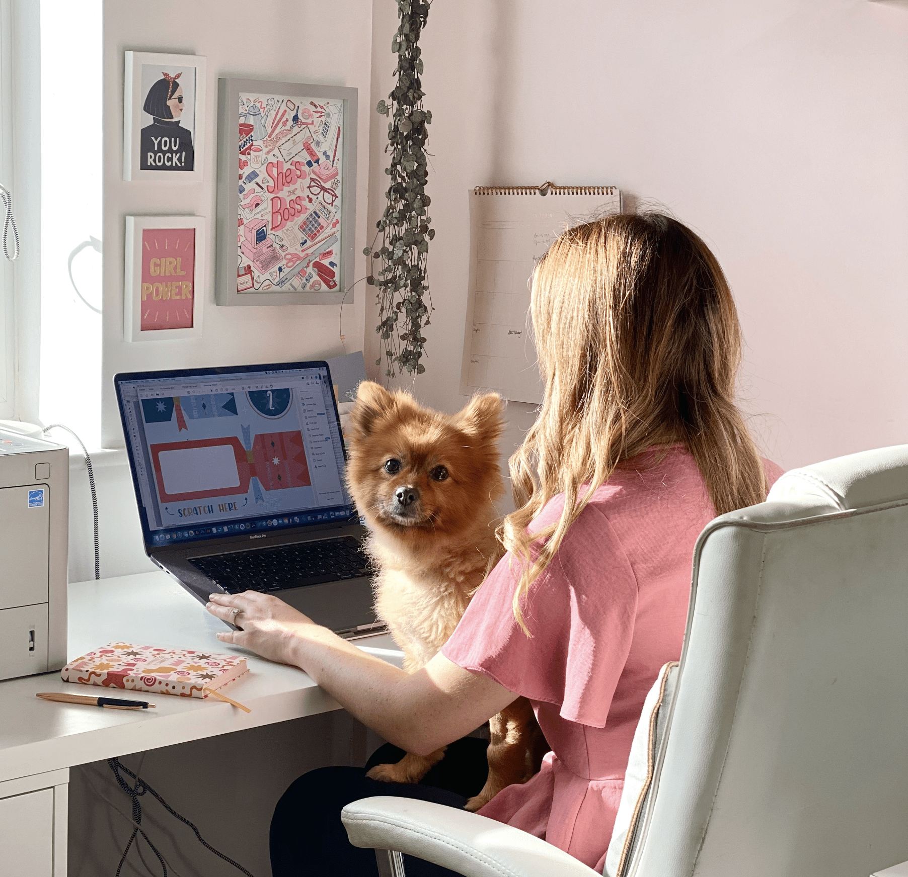 Stationery designer Bec working on Mac with dog pep